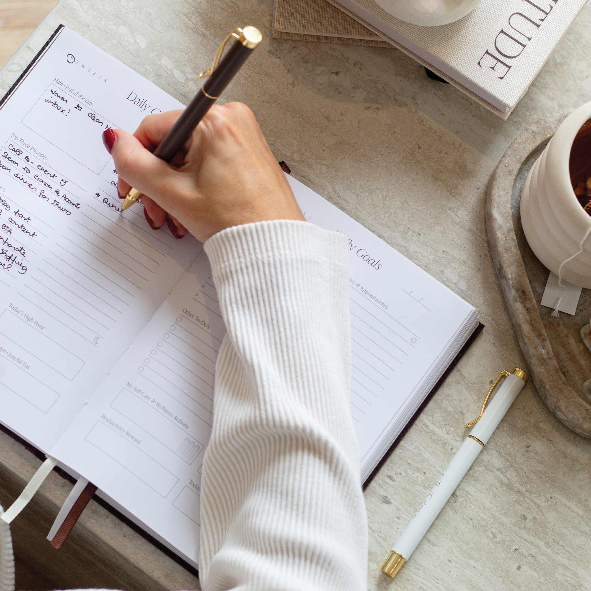 Person planning daily routine in a journal